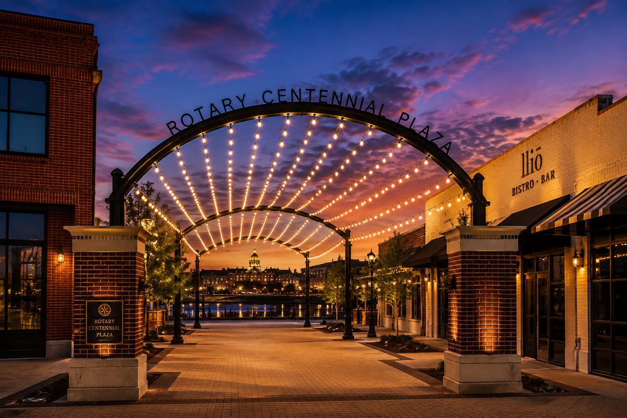 Rotary Centennial Plaza at sunset with an arch of string lights
